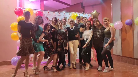 Велика компанія танцює на святі з повітряними кульками